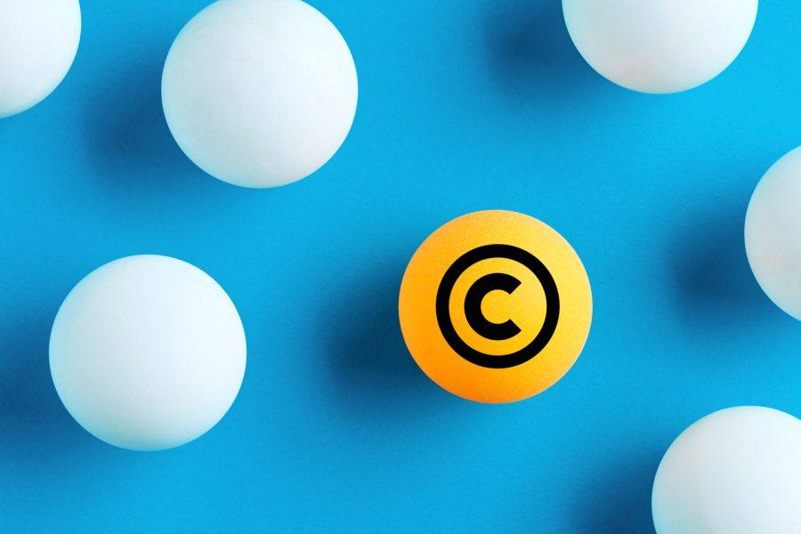Bola naranja con el símbolo de copyright entre bolas blancas sobre fondo azul